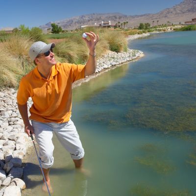 Why You Need a Golf Ball Retriever - picking a golf ball in the water - Golf Ball Monkey